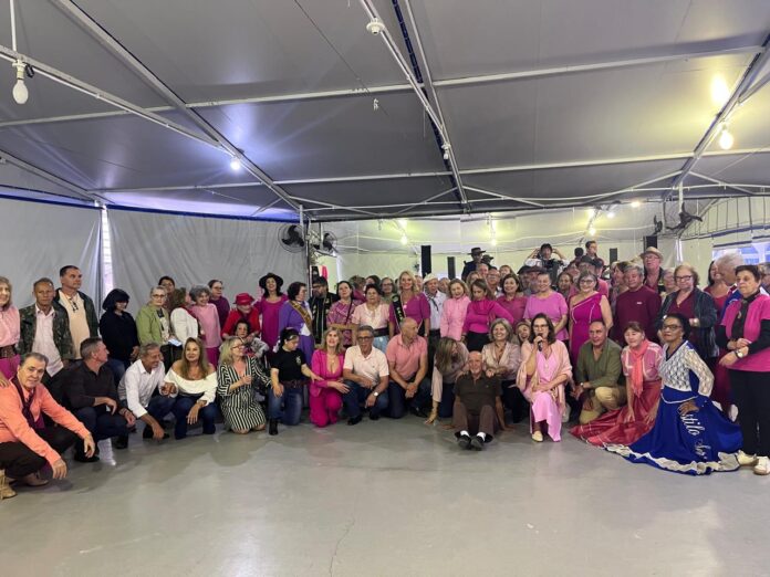 Idosos vestidos de rosa dançam em baile com chimarrão durante a Mateada Tradição Gaúcha Rosa, em Balneário Camboriú.