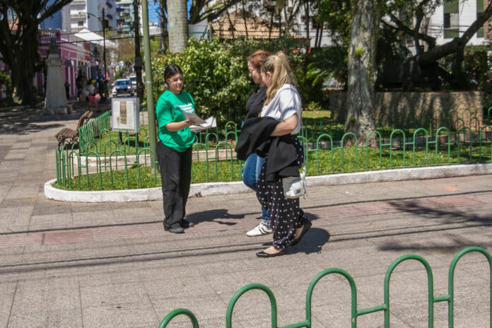 Equipe da Casan distribui o Guia de Regularização de Esgoto a moradores de Canasvieiras, em Florianópolis