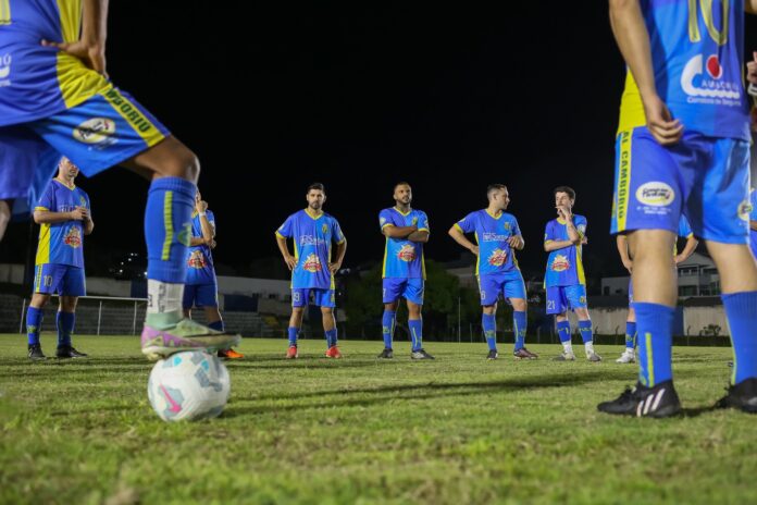 Jogadores disputam bola em partida de futebol amador em campo de bairro