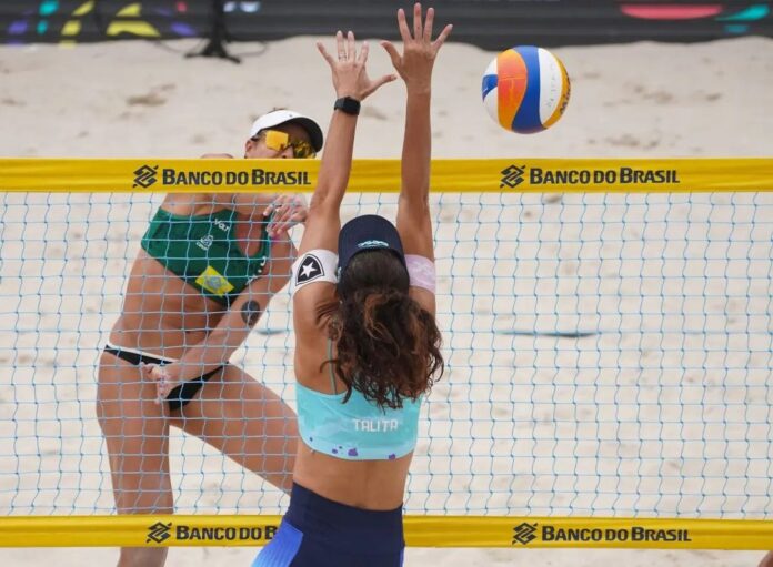 Quadra de vôlei de praia na Meia Praia, em Itapema, com atletas disputando partida