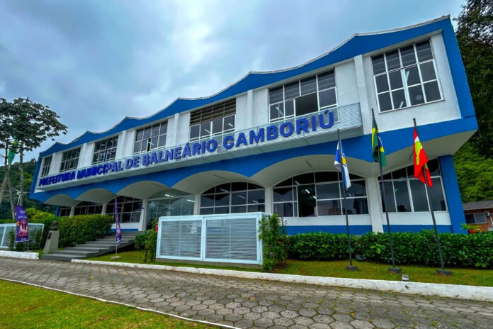 Fachada de prédio da Prefeitura de Balneário Camboriú, com aviso de ponto facultativo no Dia do Servidor Público.