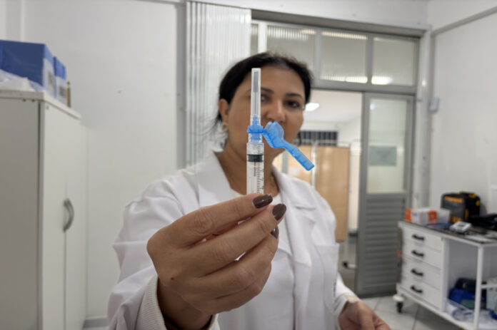 Profissional de saúde aplicando vacina em paciente em unidade básica de saúde